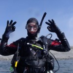 Scuba diver giving okay signal in water.