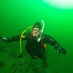 Scuba diver underwater in green-tinted sea