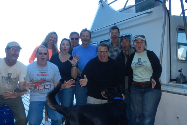 Group excited on boat with dog