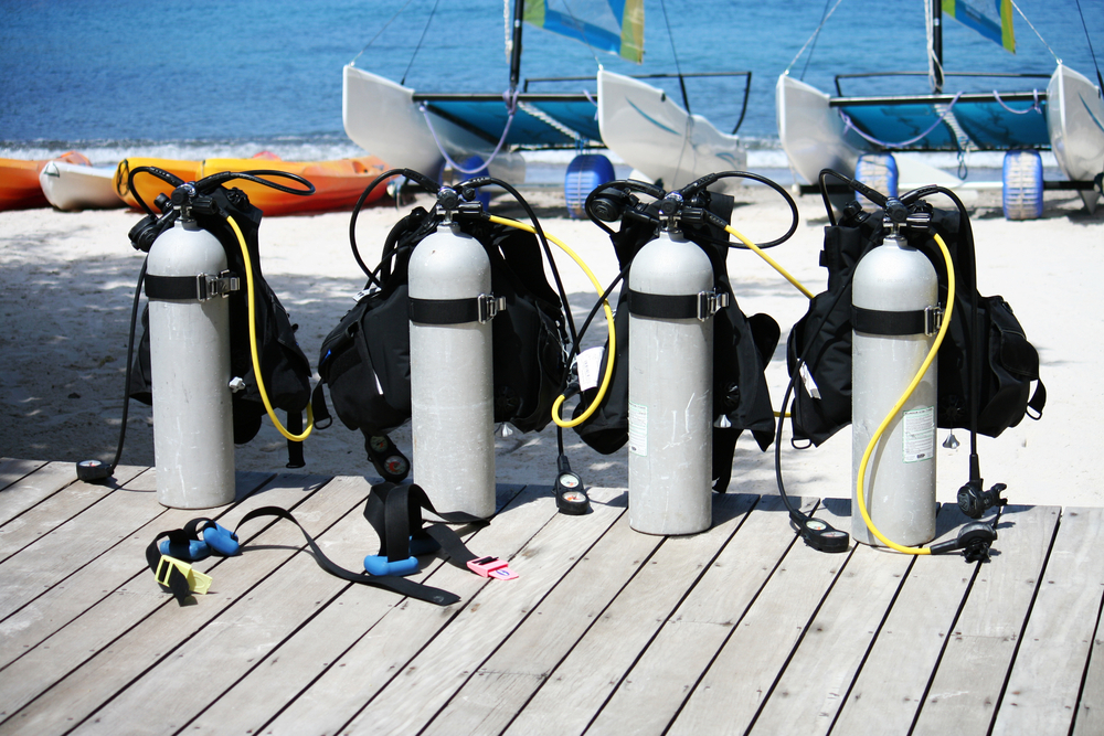 Scuba tanks on wooden deck near beach