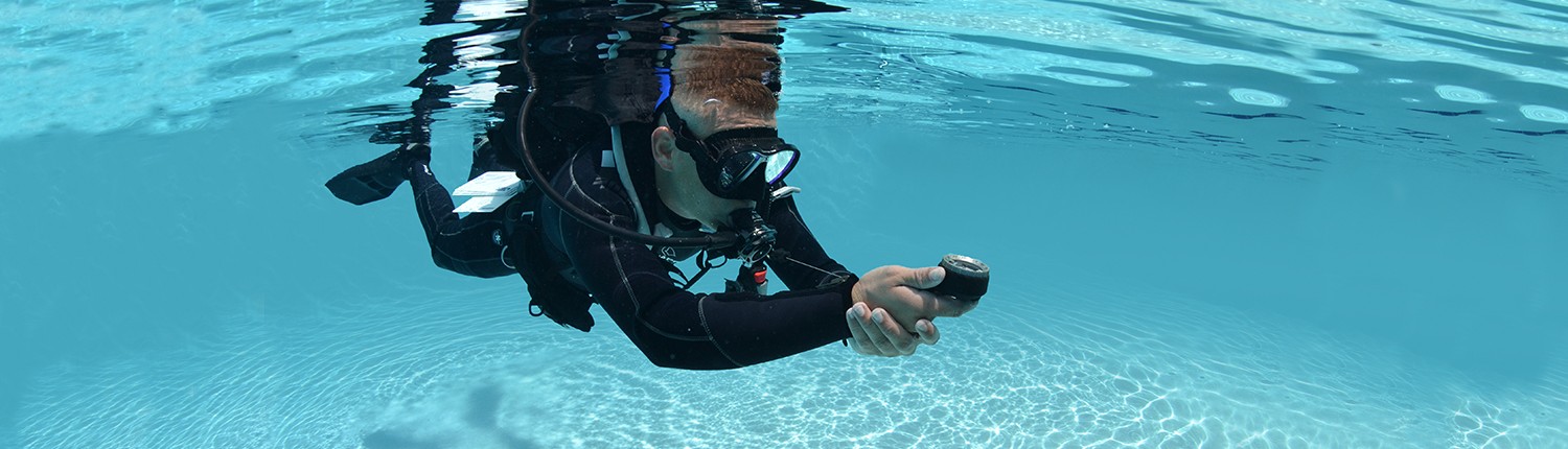 Scuba diver underwater in clear pool.