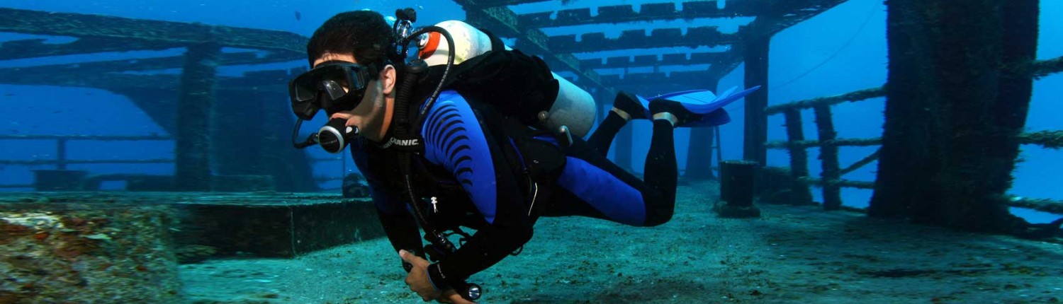 Scuba diver exploring underwater shipwreck scene