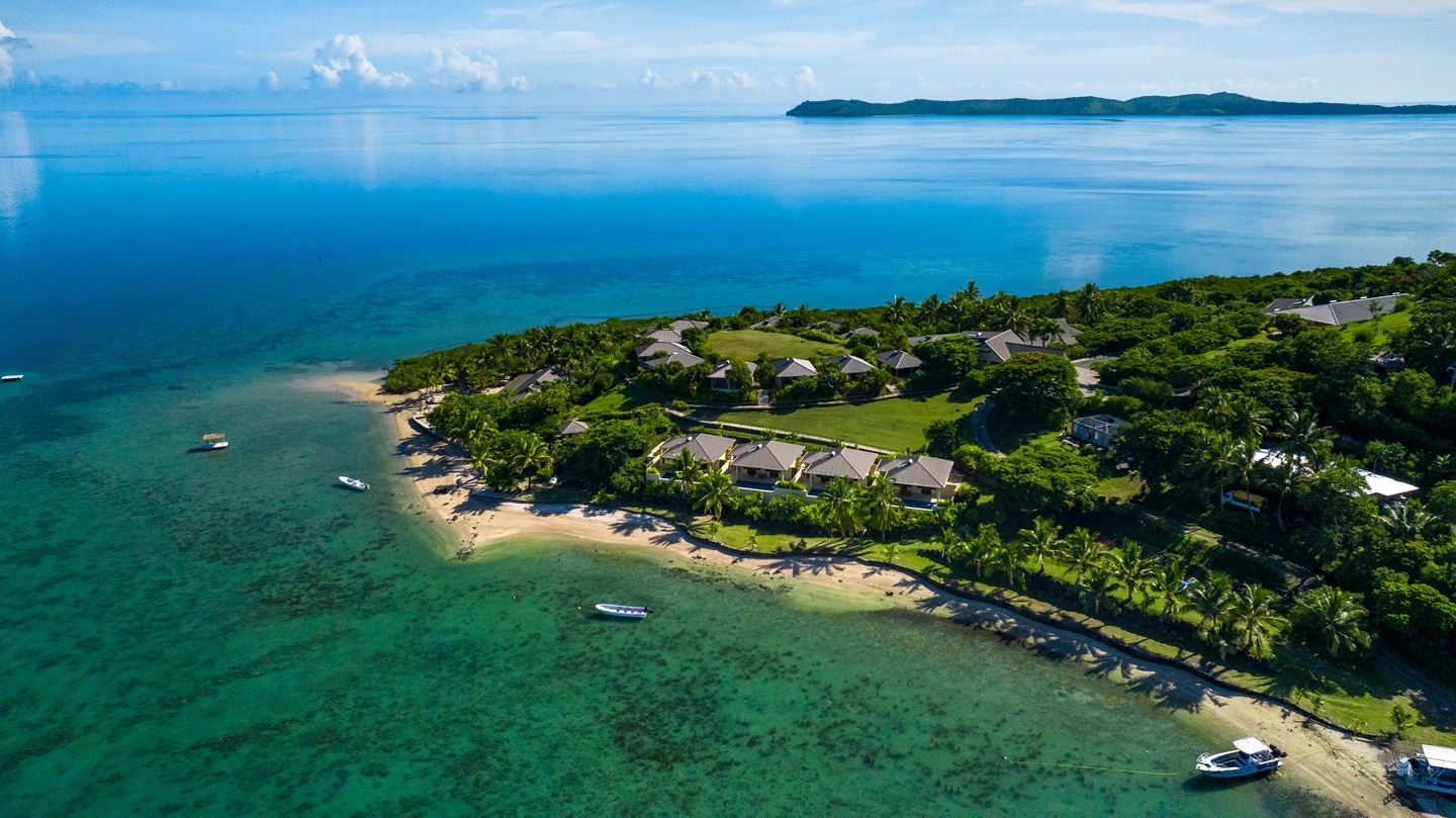Tropical island coastline with lush greenery and ocean.