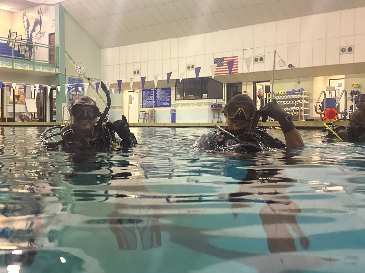 Scuba divers in indoor pool training session